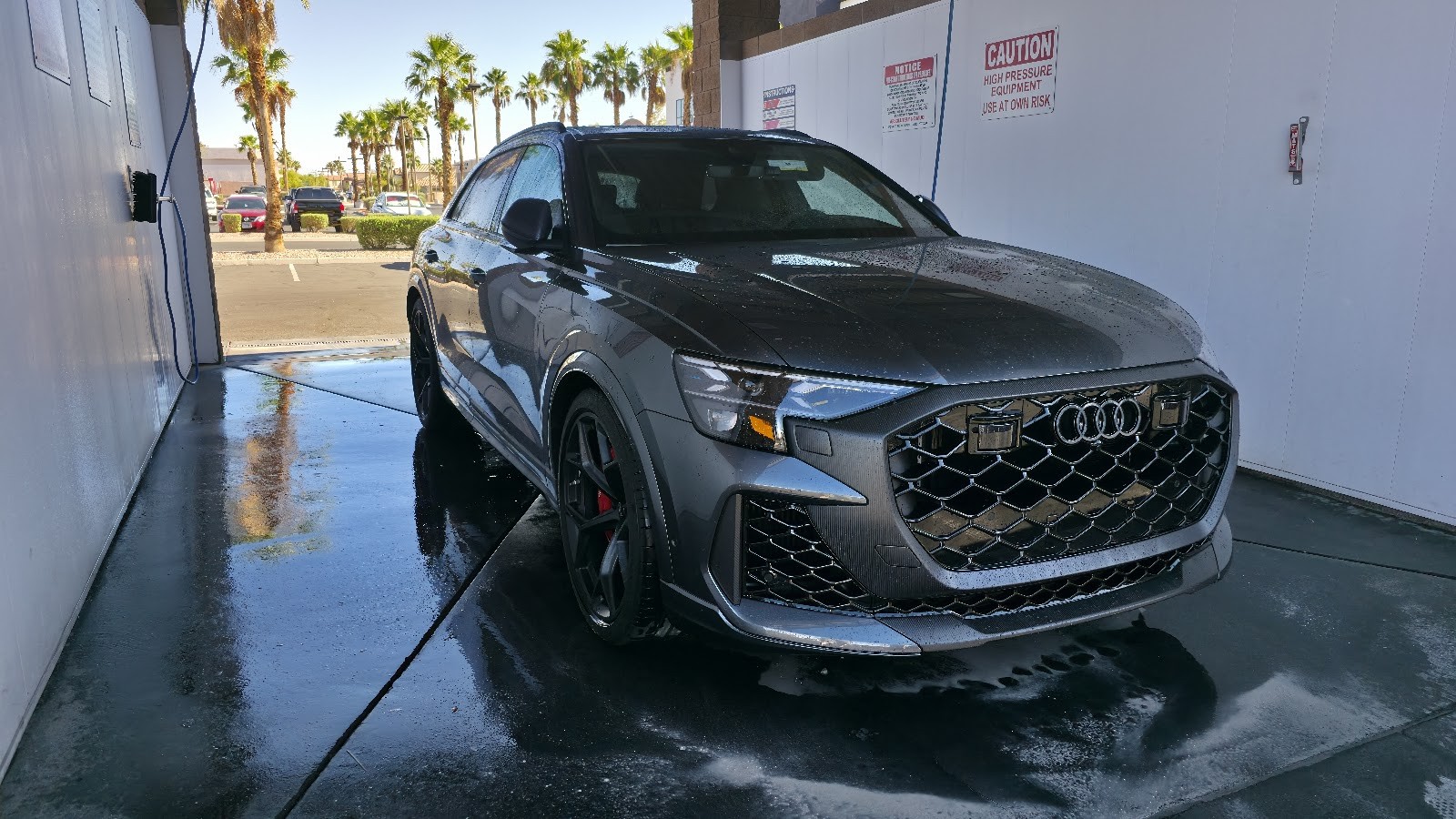 Grey Audi RS Q8 SUV being washed at a self-serve bay