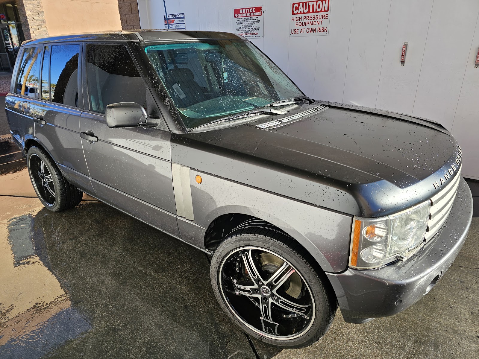 Clean wet Range Rover with beaded water at a car wash bay