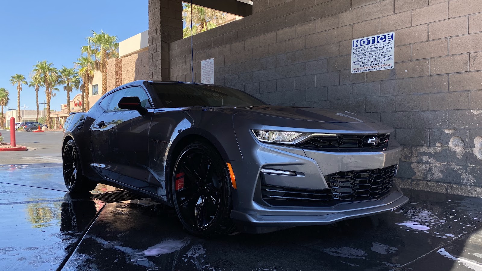 Grey Chevrolet Camaro SS with black wheels at a self-serve car wash bay